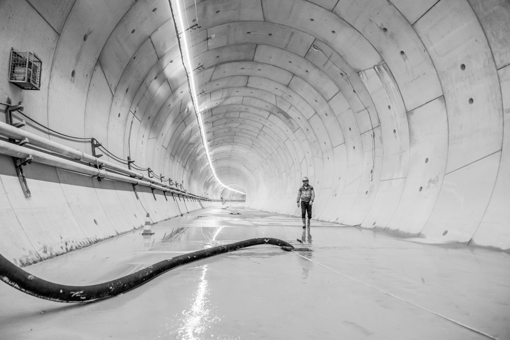 Un homme marche face à la caméra dans un tunnel.