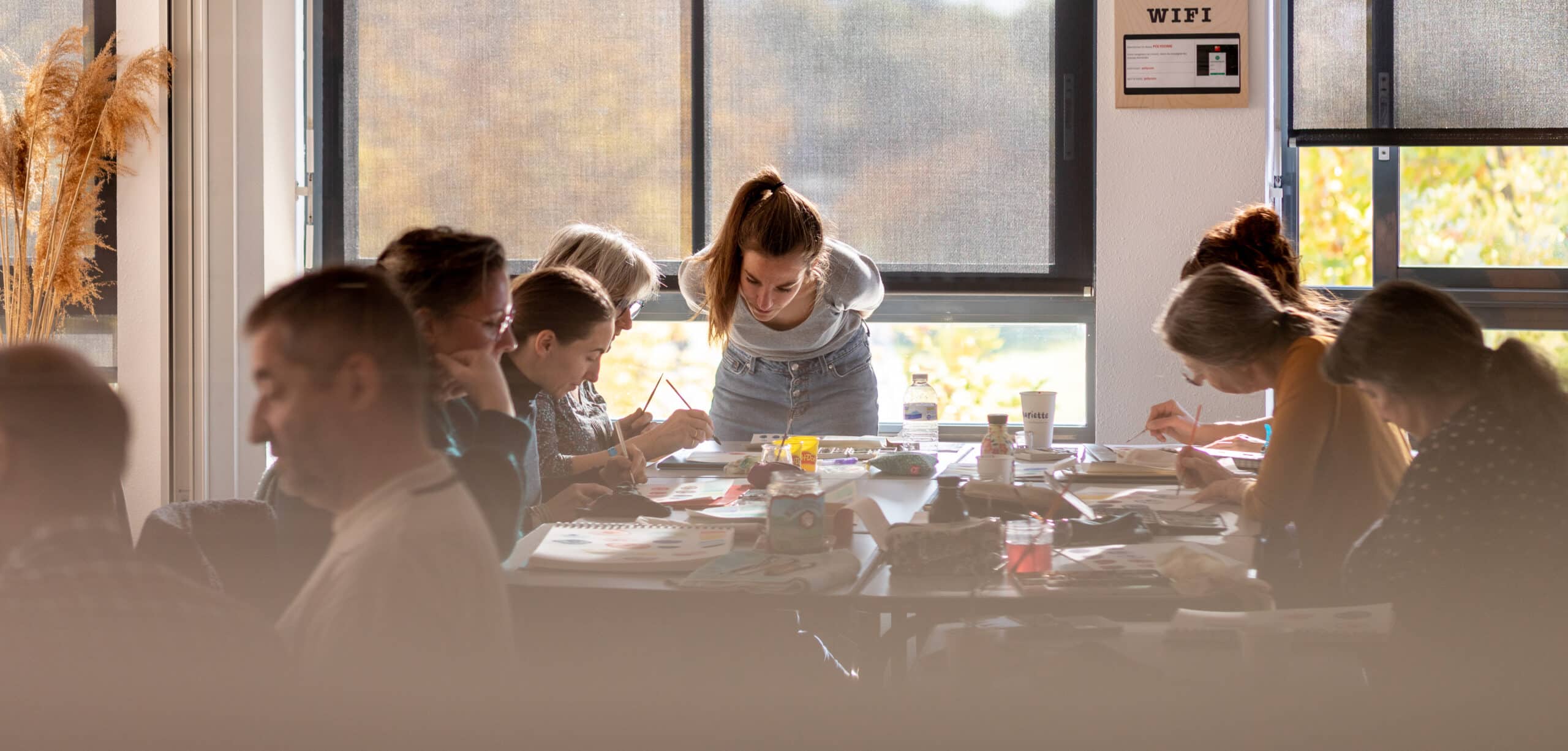 Groupe de personne dans une salle pour un atelier de peinture.